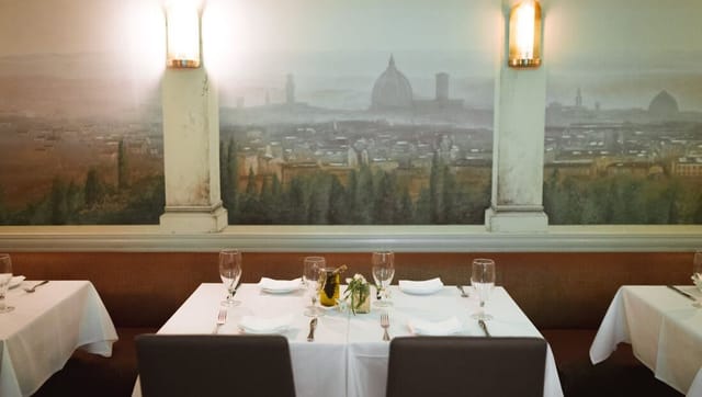 Elegant dining table with white linens in Zingari for upscale events and receptions.