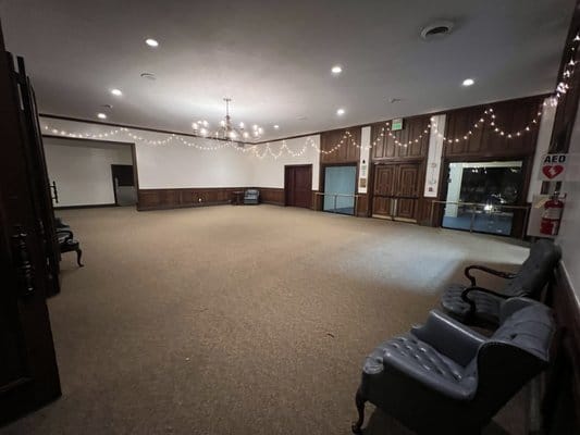 Main Room at Albert H. DeWitt Officers' Club, spacious venue with elegant chandeliers for events.