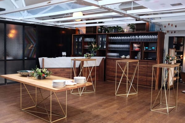 Elegant event space with wooden tables, ideal for upscale networking and cocktail receptions.
