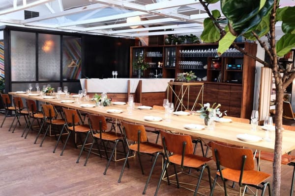 Californian restaurant event space with wooden table, ideal for intimate gatherings and corporate dinners.