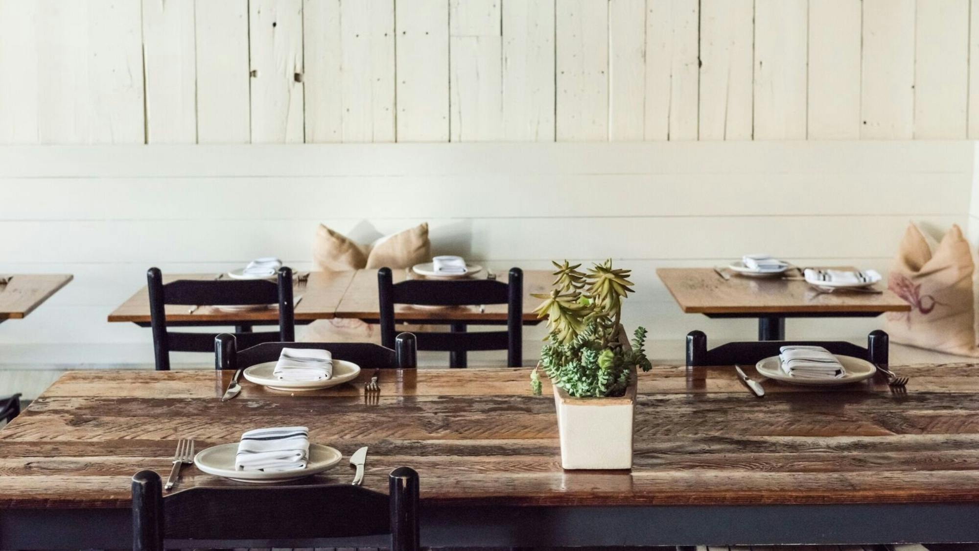 Intimate dining space with rustic wooden tables for gatherings and meetings.