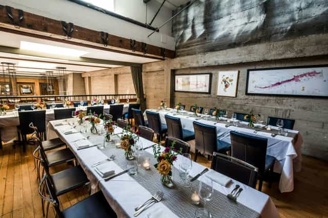 Stylish Mezzanine event space with elegant floral centerpieces for corporate gatherings.