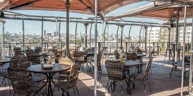 Stylish rooftop bar in Lolinda with city skyline, perfect for events and gatherings.