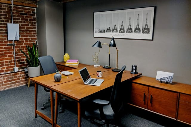Modern day office for meetings in Trellis Coworking, featuring a warm brick wall.