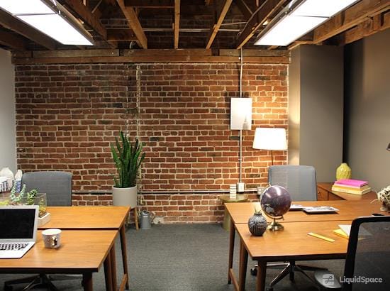 Cozy day office with exposed brick, ideal for meetings and coworking events.