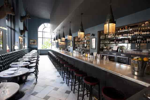 Stylish bar area with marble tables at The Rail Car, perfect for networking events.