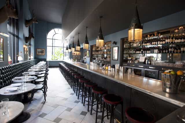 Stylish bar area with marble tables at The Rail Car, perfect for networking events.