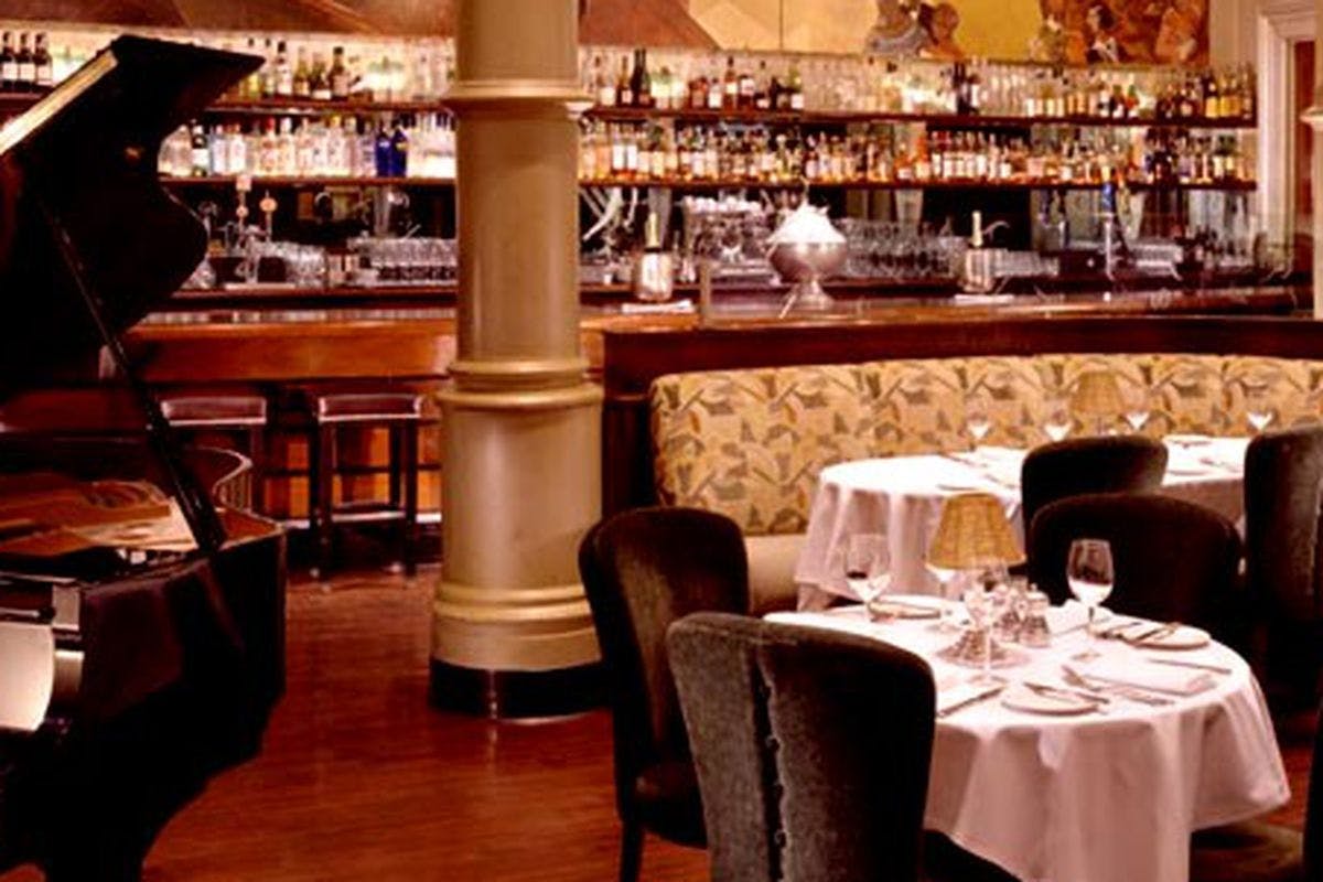 Elegant dining room in BIX San Francisco, featuring plush seating and a grand piano.