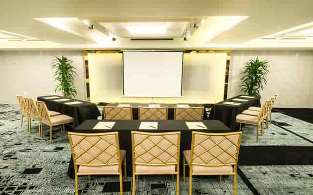 Event Space in Hotel Fusion with U-shaped tables for professional meetings and workshops.