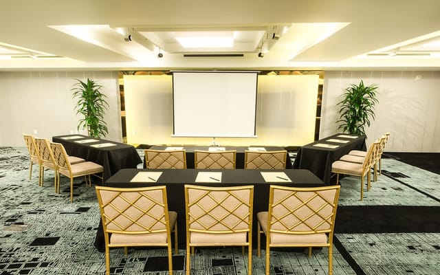 Event Space in Hotel Fusion with U-shaped tables for professional meetings and workshops.