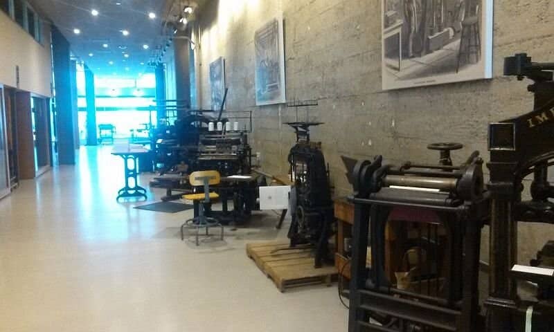 Vintage printing equipment in spacious American Bookbinders Museum workshop venue.