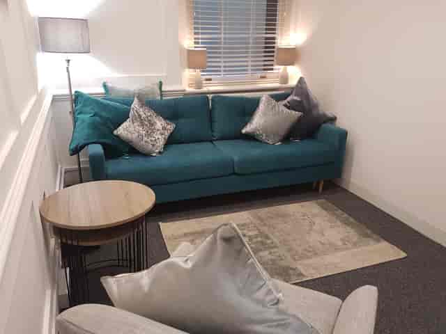 Cozy Pilgrim Suite with plush teal sofa for creative meetings and brainstorming.