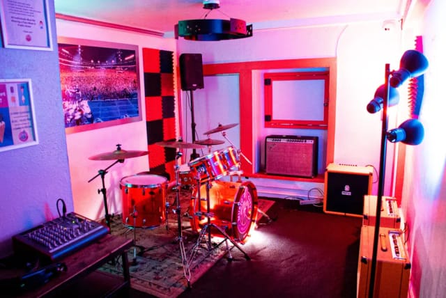 Vibrant rehearsal space with drum set, ideal for live music events and team-building activities.