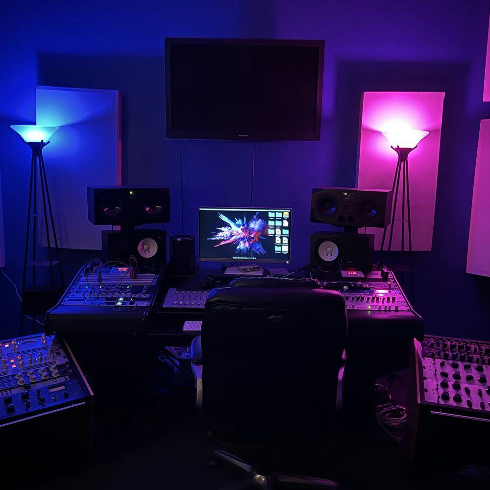 Modern audio control room with vibrant lighting for creative workshops and recording sessions.