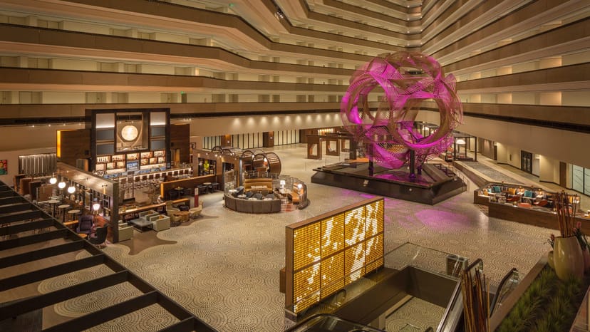 Modern hotel lobby with pink sculpture, ideal for events and gatherings.