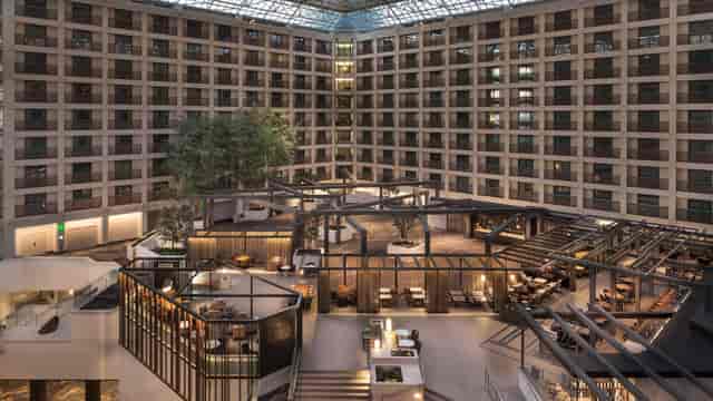 Modern hotel atrium with glass ceiling, ideal for conferences and social events.