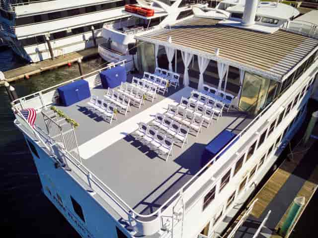 Outdoor event space on a boat with arranged chairs for corporate gatherings.