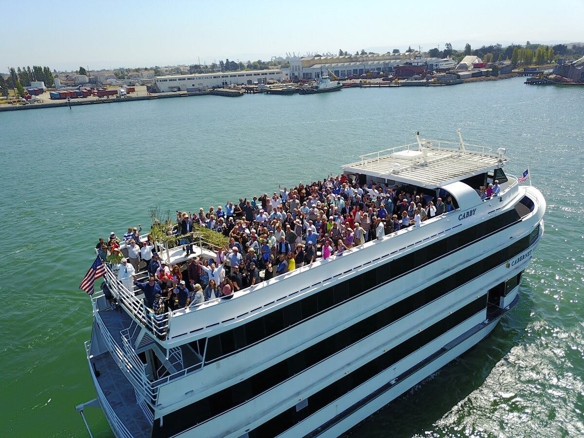 Pinot Noir event on cruise ship deck with scenic waterfront view, ideal for networking.