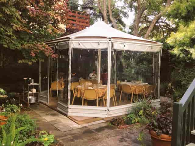 Elegant outdoor gazebo with table settings for intimate gatherings and events.