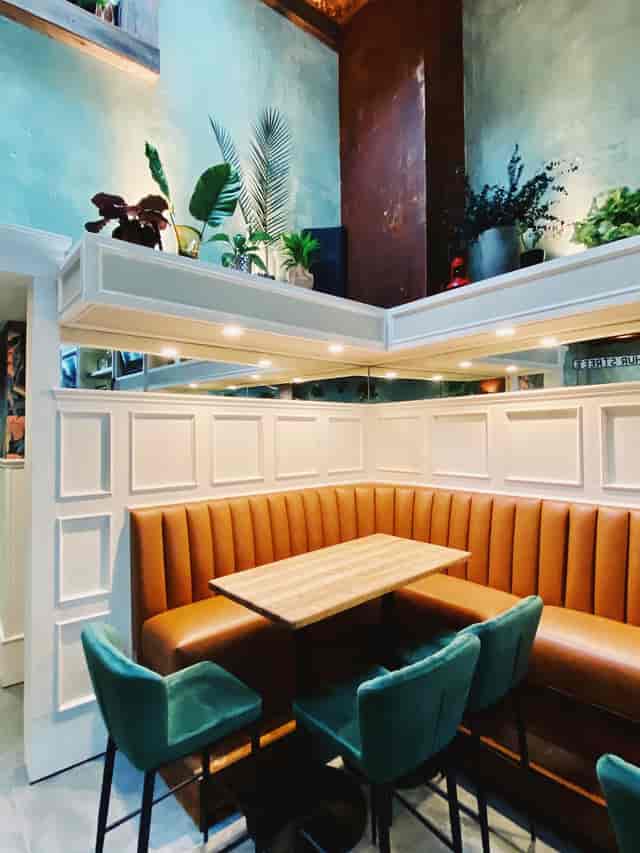 Stylish meeting space with cozy booth and wooden table for small group discussions.