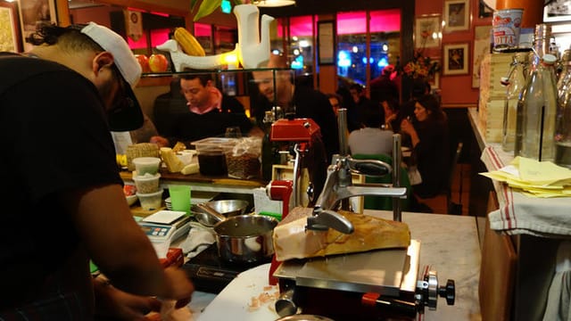 Vibrant InoVino wine bar with chef preparing food for lively dining events.
