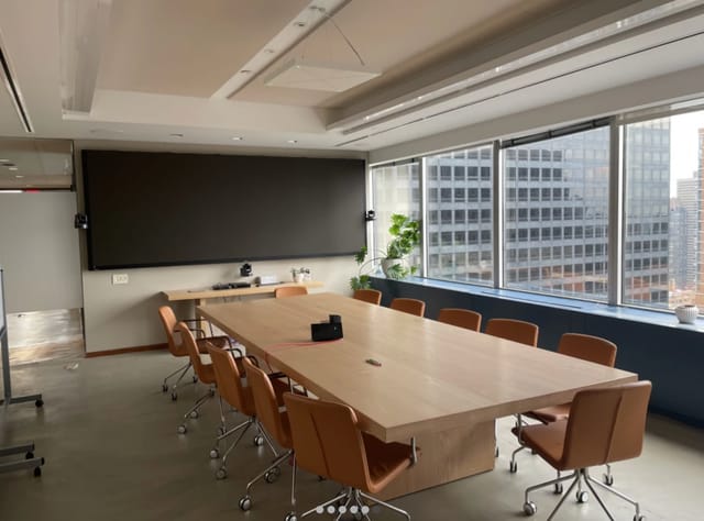 Modern conference room with large screen, ideal for corporate meetings and presentations.