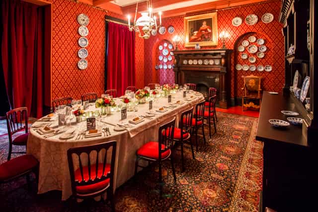 Elegant corporate reception space with rich red walls, ideal for intimate events and meetings.