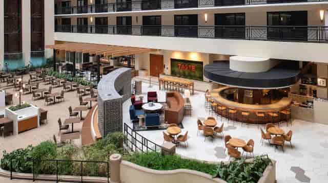 Spacious hotel atrium with modern bar, perfect for meetings and events.