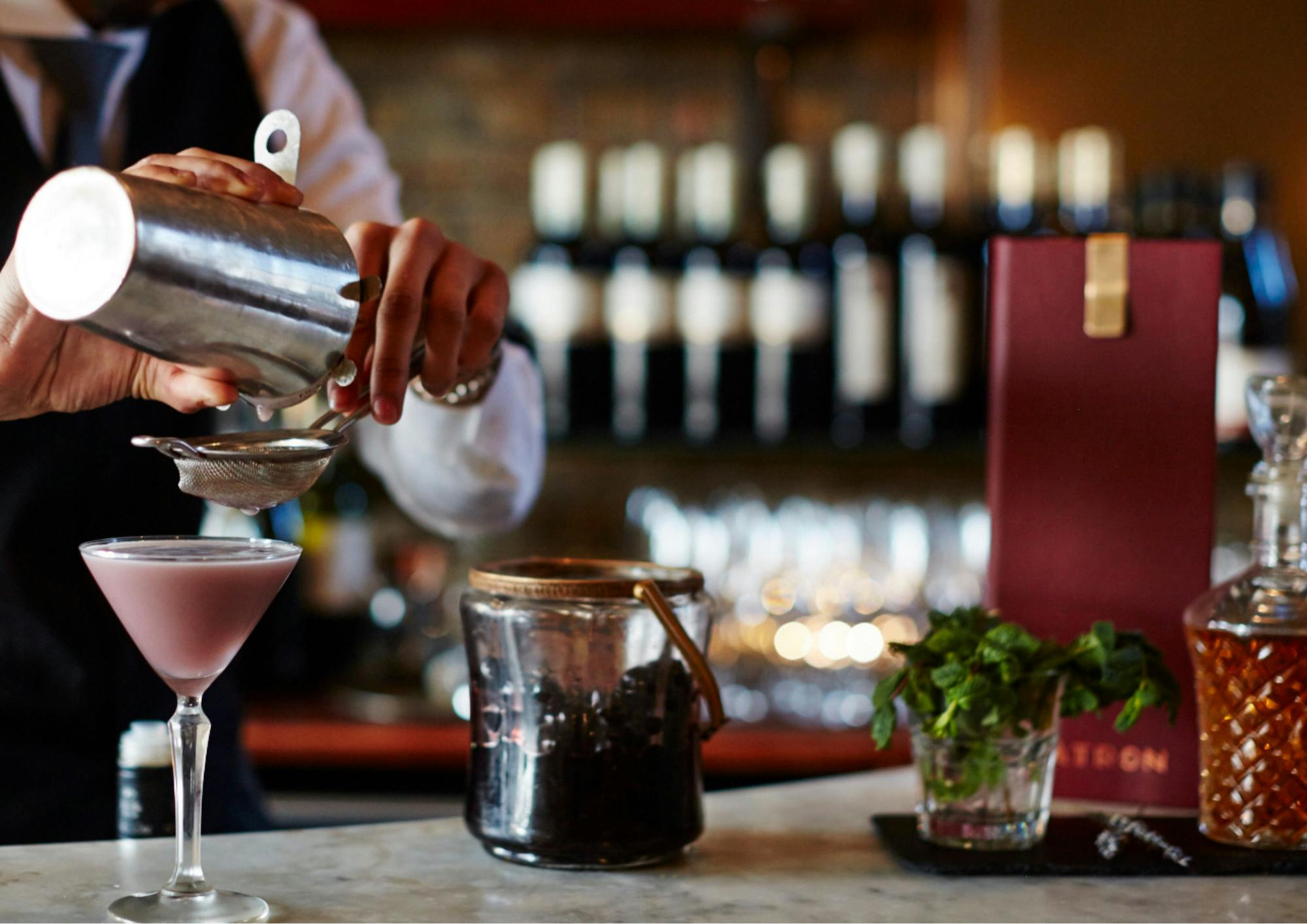 Bartender crafting a cocktail at Patron Restaurant's Bar & Bistro for upscale events.