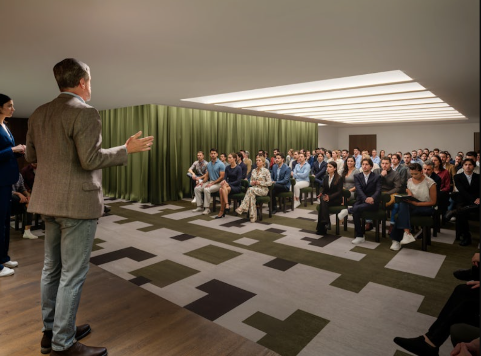 Attentive audience in modern Town Hall meeting space for seminars and presentations.