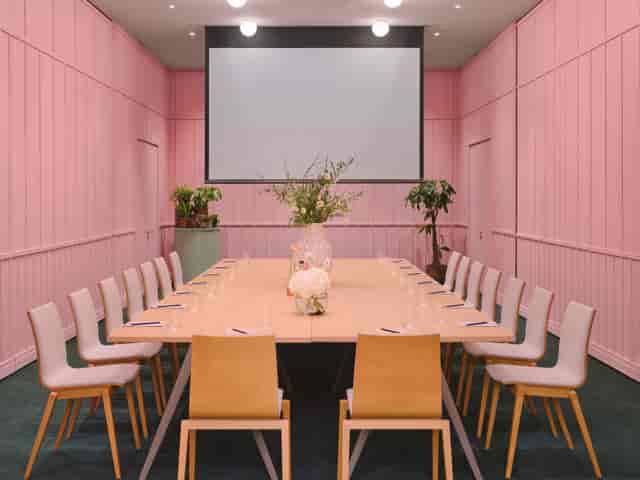 Modern meeting room with elegant table and pink walls at art'otel London Battersea.
