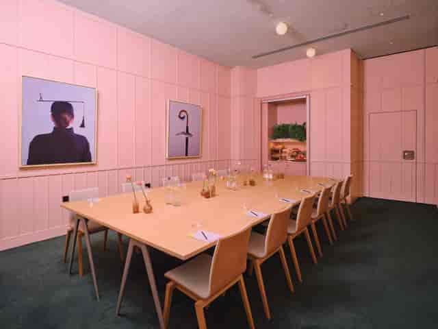 Modern meeting room with pink decor, ideal for creative brainstorming sessions.