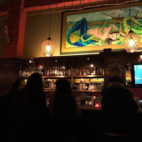 Vibrant bar with mermaid mural, perfect for social gatherings and themed events.