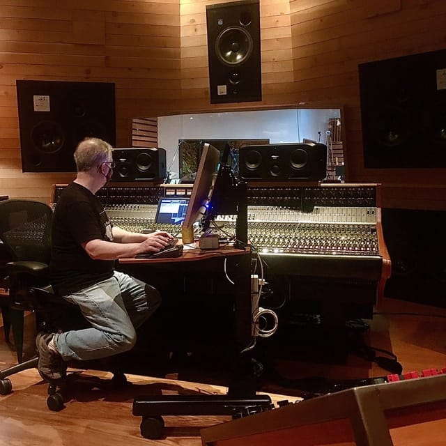 Sound engineer at mixing console in Suite 1, enhancing audio quality for events.