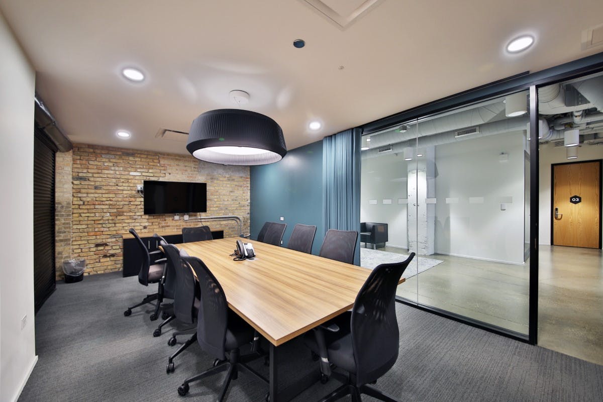 Modern conference room with spacious table and glass windows for effective meetings.