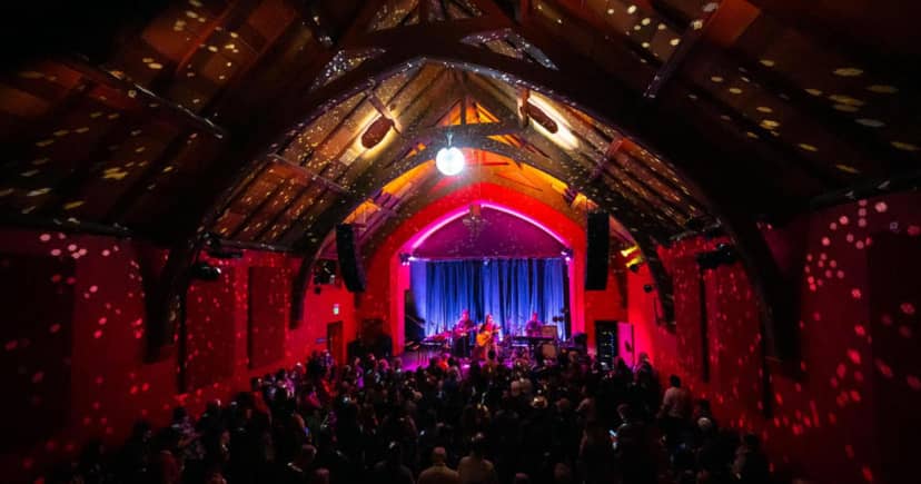 Vibrant event space with disco ball and wooden beams for concerts at The Chapel.