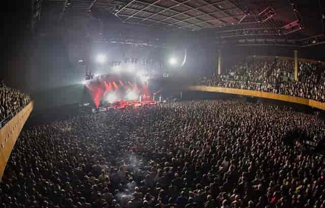 Packed Bill Graham Civic Auditorium concert with vibrant stage lighting and engaged crowd.
