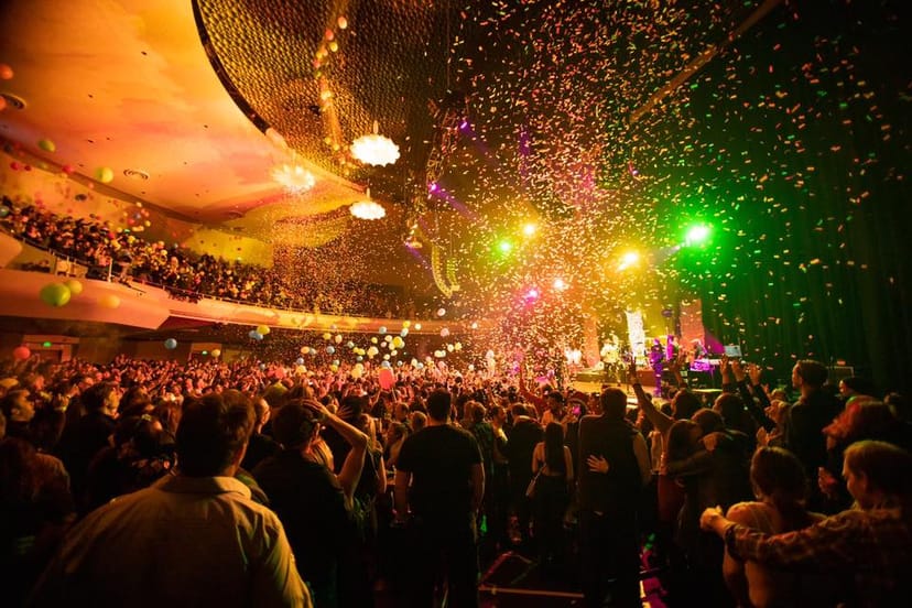 Vibrant SF Masonic Auditorium event with balcony, confetti, and colorful lights.