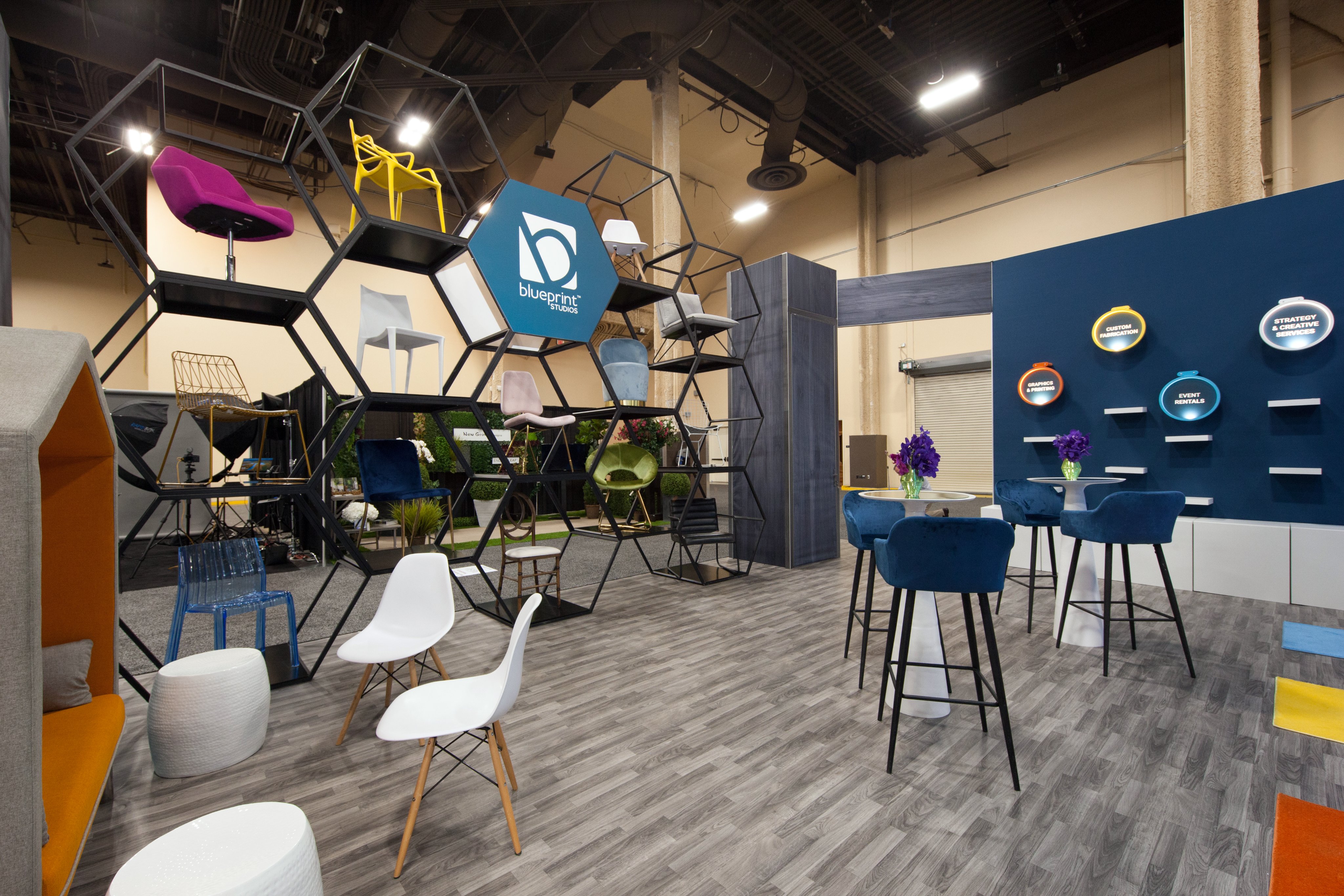 Modern trade show booth with hexagonal design and vibrant seating for networking.