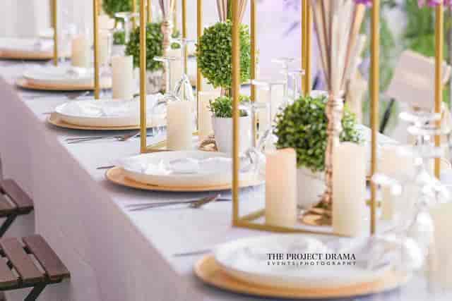Elegant dining table with greenery and candles for weddings or corporate events.