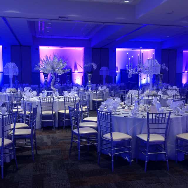 Grand Ballroom with elegant tables and blue lighting for weddings and corporate events.