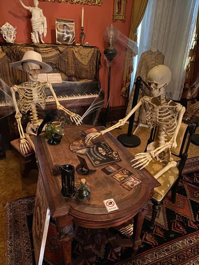 Haunted Garden with skeletons at rustic table, perfect for Halloween parties and events.