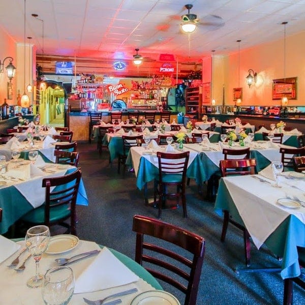 Private dining room with floral centerpieces for intimate events at Ristorante Buon Gusto.
