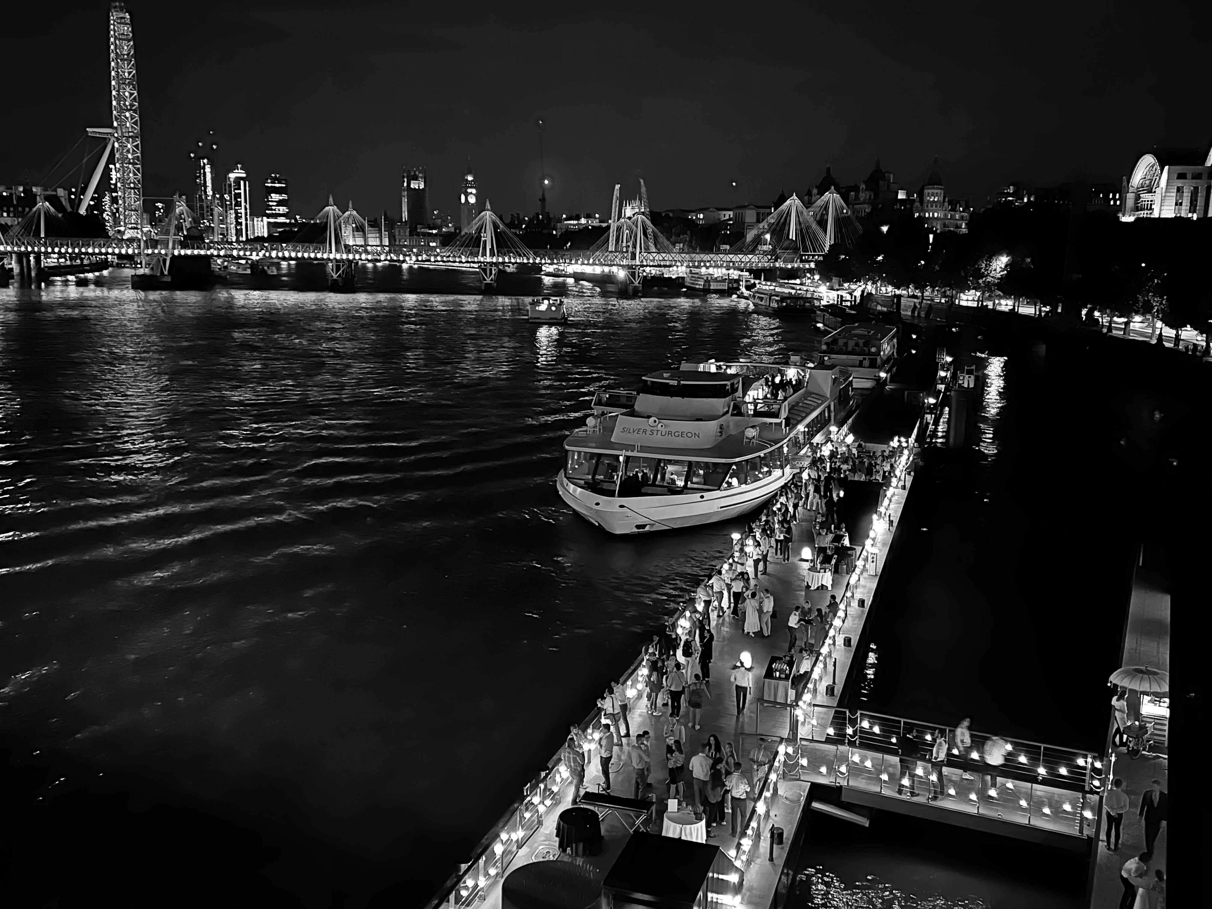 Elegant riverside venue for large events, featuring ambient lighting and city skyline.