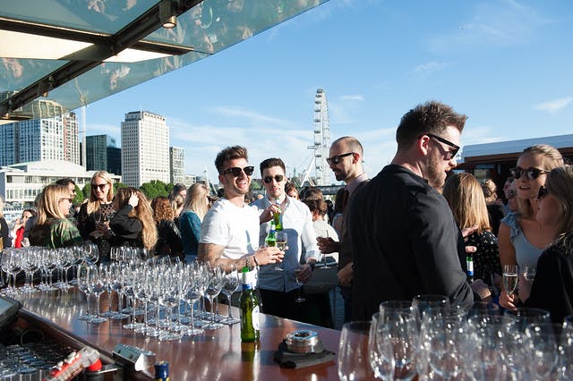 Rooftop event for 900 guests with stylish bar setup, perfect for networking and socializing.