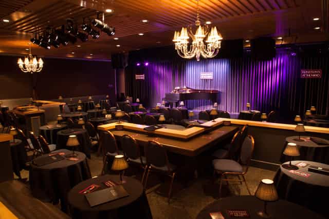 Intimate concert hall at Feinstein's, featuring elegant lighting and professional stage setup.