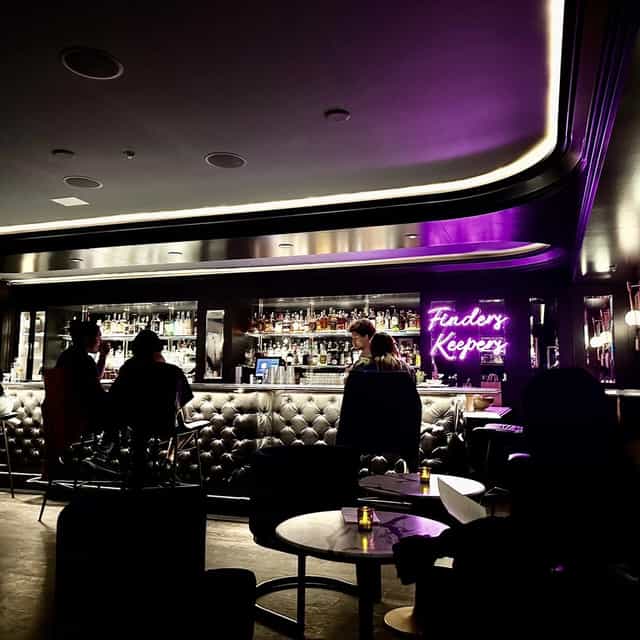 Stylish bar with neon sign, perfect for networking events and cocktail receptions.
