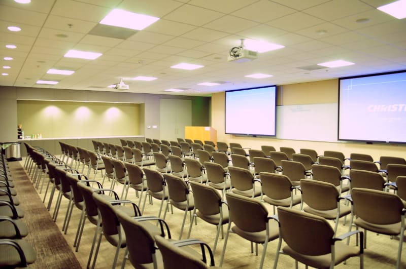 Conference room Suite 105 with dual screens, ideal for workshops and presentations.