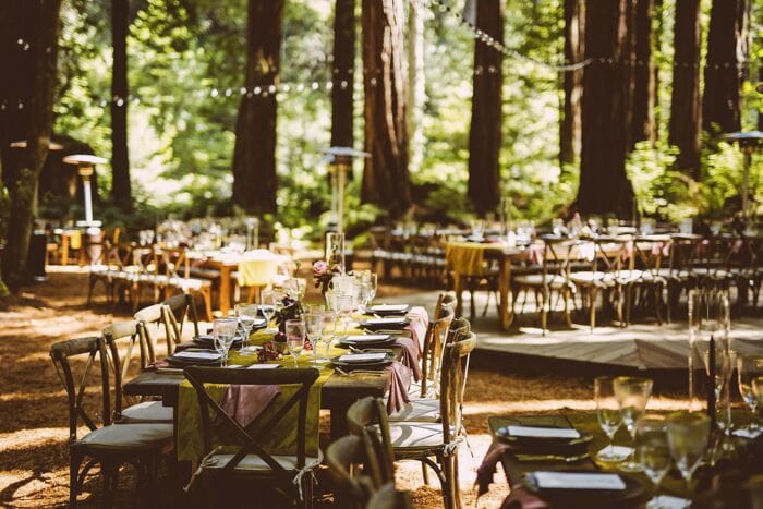Outdoor dining setup with rustic tables, ideal for weddings and corporate retreats.
