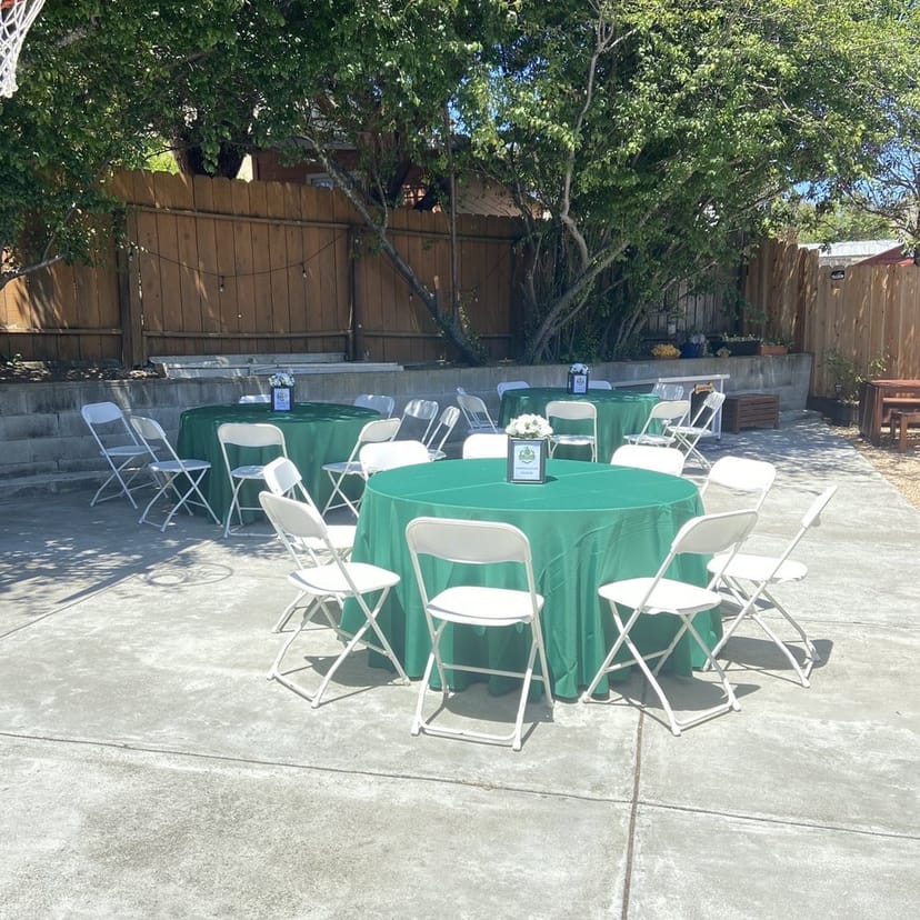 Outdoor event setup with round tables and green tablecloths, perfect for gatherings.